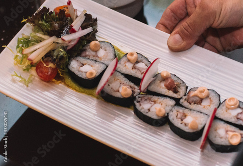 Unas piezas de sushi con salsa de soja sobre una tabla