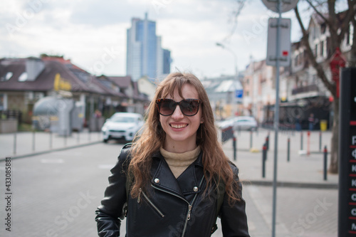 Summer sunny lifestyle fashion portrait of young stylish hipster woman walking