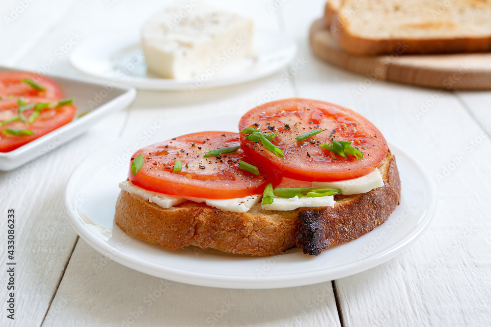 Whole grain bread with goat cheese and fresh tomatoes. Healthy and tasty breakfast. Whole grain bread with goat cheese and fresh tomatoes. Healthy and tasty breakfast.