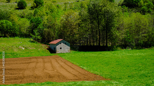 mountain rural house surrounded by greenery with plowed land. Valley of the Orchids, Campania, Italy photo