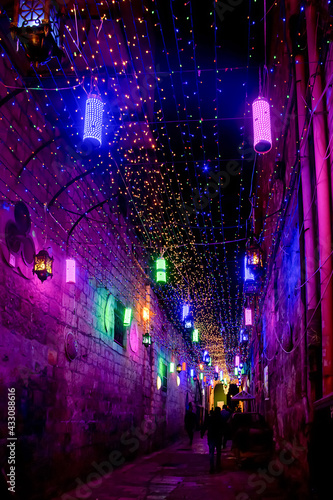 evening or night Street of the old city of Jerusalem decorated with bright multi-colored bulbs for Ramadan in the Arab quarter of Jerusalem's Old City.