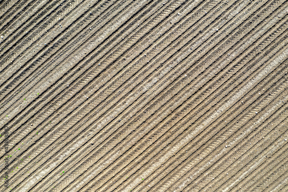 Clear plowed field with traces. View from the top. Clear plowed field with traces. View from the top.