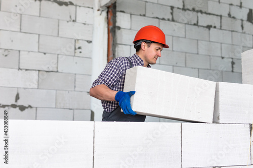 Canvas Print Bricklayer builder working with autoclaved aerated concrete blocks