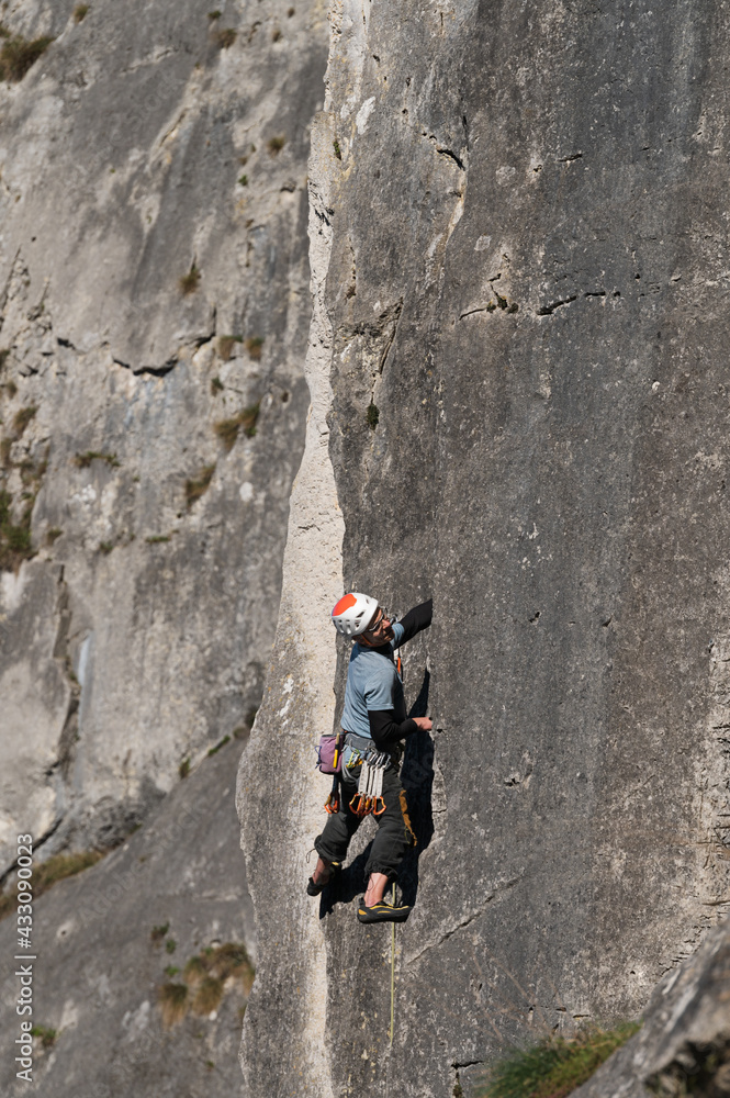Male climber with a helmet explores the climbing route. Male climber with a helmet explores the climbing route.