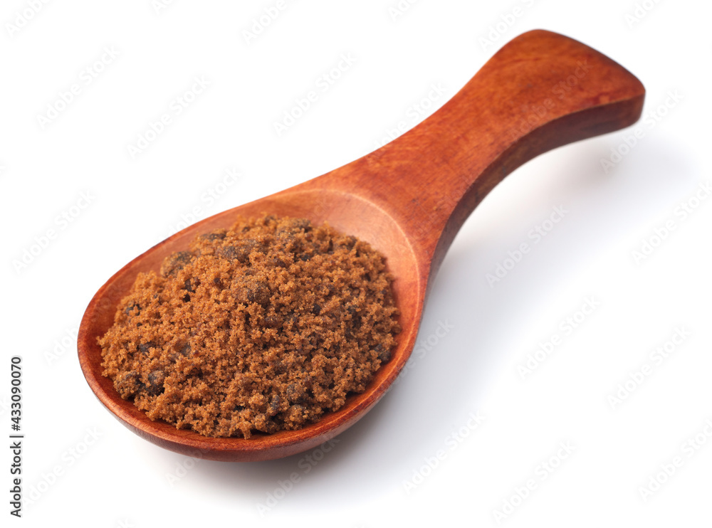 brown sugar in the wooden spoon, isolated on white background