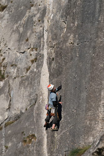Male climber with a helmet explores the climbing route.