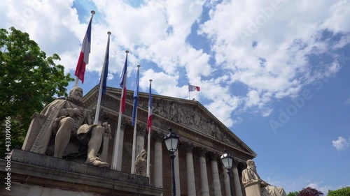 French National Assembly building with French and EU flags waving - Paris, France.