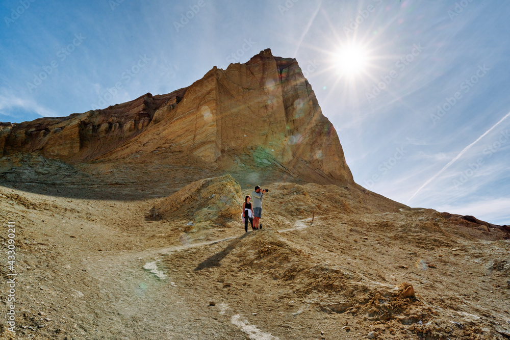 A family hike from Zabriskie Point in Death Valley national park in california. Huge sand dunes, terracotta mountains and hazy horizons are shining against clear blue sky in the midday sun. A family hike from Zabriskie Point in Death Valley national park in california. Huge sand dunes, terracotta mountains and hazy horizons are shining against clear blue sky in the midday sun.