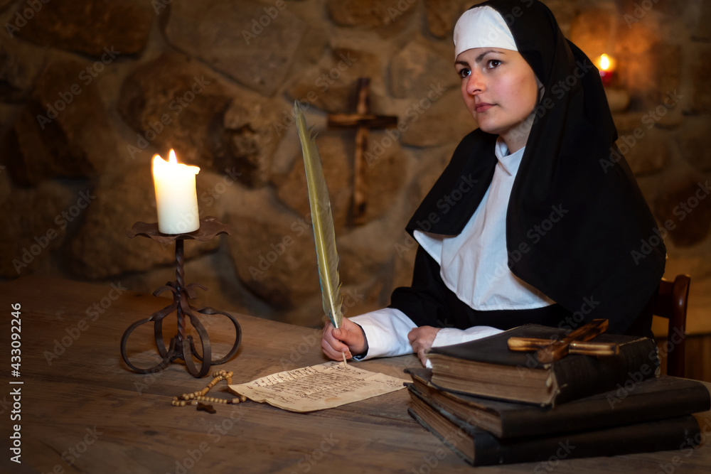 Obraz premium Young medieval nun writes a letter