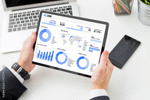 Man viewing infographics on the tablet computer indicating different business data