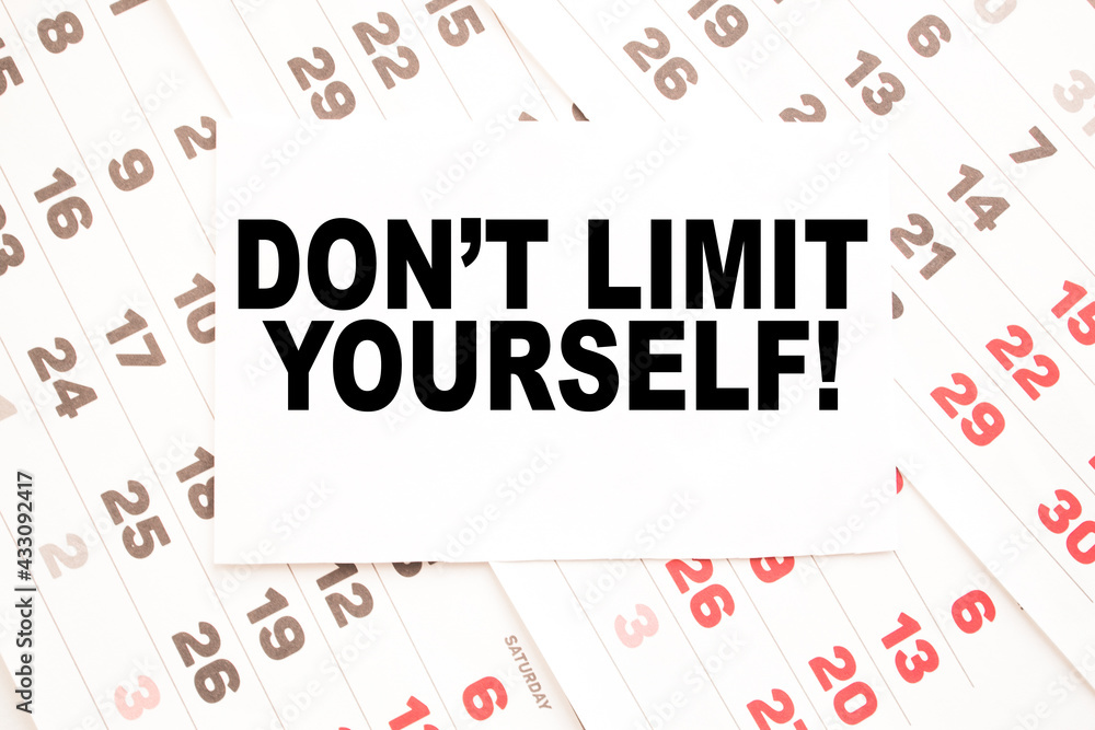 Notepad with text DON'T LIMIT YOURSELFE on the office desk with stationery. A blank notepad for entering a copy or text. business Notepad with text DON'T LIMIT YOURSELFE on the office desk with stationery. A blank notepad for entering a copy or text. business