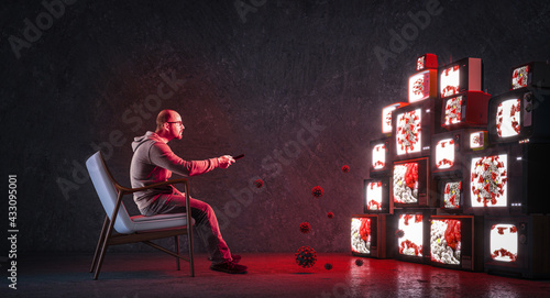 man on an armchair watching many televisions photo