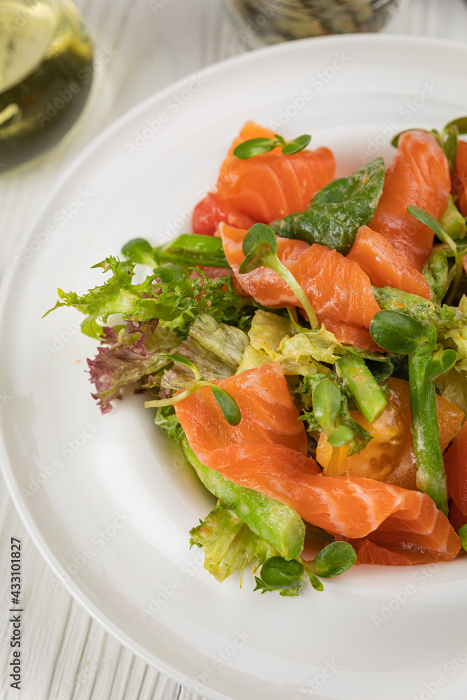 Salmon, asparagus and greens salad. On a white plate and white table.
Salmon, asparagus and greens salad. On a white plate and white table.