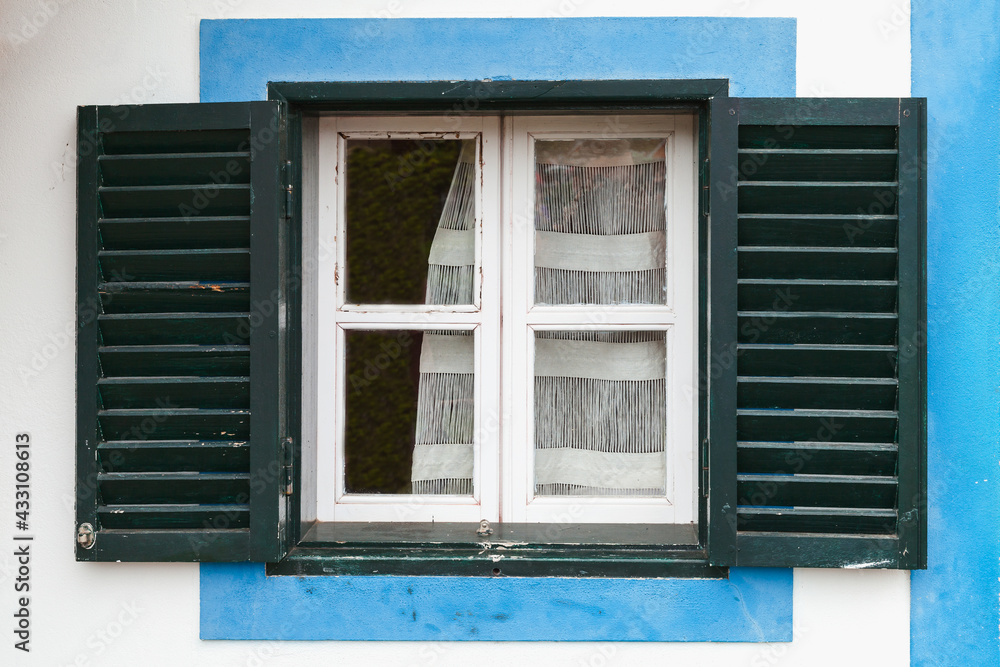 Window with open dark green shutters
