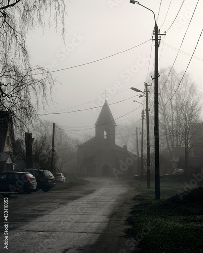 church in the fog gloomy old church in the morning mist on a city street