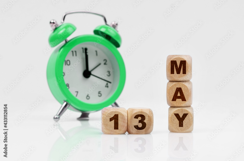 On a white background there is an alarm clock and a calendar with the inscription - MAY 13 On a white background there is an alarm clock and a calendar with the inscription - MAY 13
