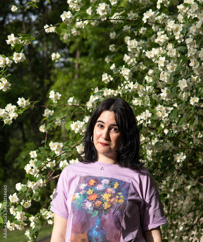 Photo of an attractive woman with black hair in the middle of nature during spring time, walking around and smiling during a sunny day Photo of an attractive woman with black hair in the middle of nature during spring time, walking around and smiling during a sunny day