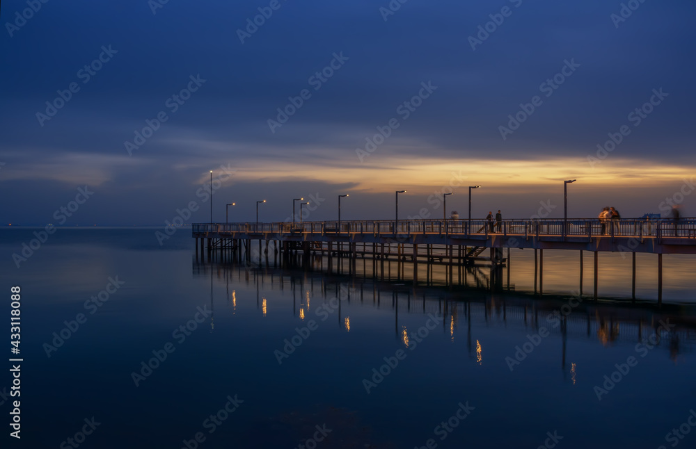 Fototapeta premium Sunset or sunrise reflection in nature with sun in clouds above black sea scenery.