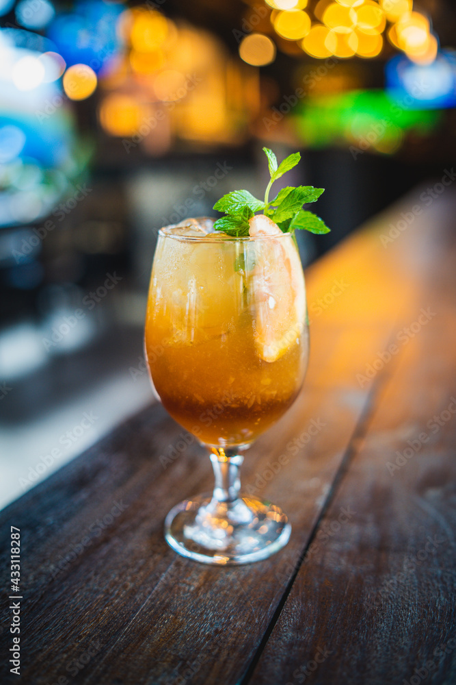 Mai tai drink beverage alcohol with lemon and mint in counter. Bokeh, bar