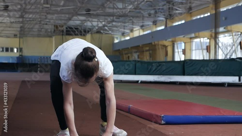 girl - a child shows exercises before the competition for body flexibility in the sports hall. The child is a gymnast. Children photo