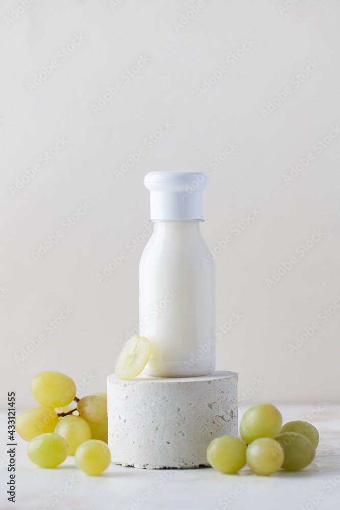 Grape cosmetics. A tube of cream, lotion for the skin of the face and body with grape extract on a pedestal. Copy space. Grape cosmetics. A tube of cream, lotion for the skin of the face and body with grape extract on a pedestal. Copy space.
