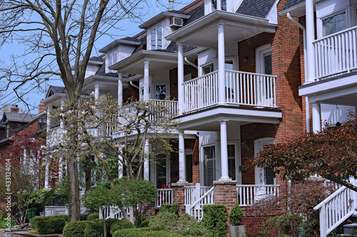 Photography Street with row of attached older brick townhouses with second floor balconies a
