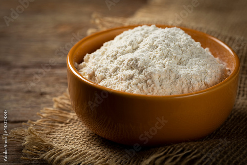 Bowl with wheat flour on the table.