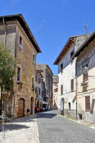 Sermoneta, Italy, 05/10/2021. A street between old medieval stone buildings in the historic town.