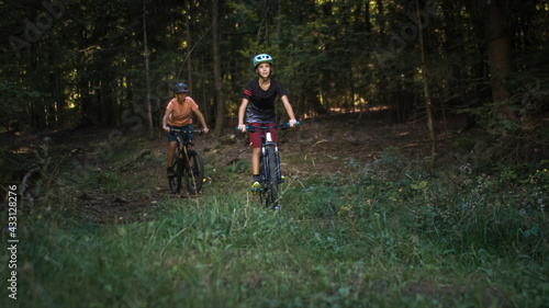 Two girls on mtb bikes. Mother and daughter riding on a forest trail. © 24K-Production