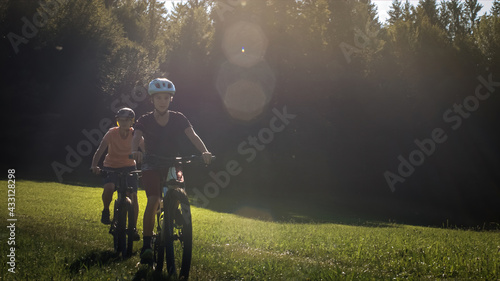 Two girls on mtb bikes. Mother and daughter riding on a forest trail.