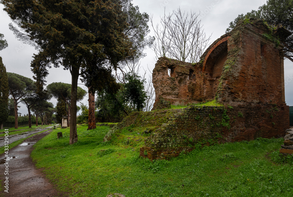 Appia Antica after the storm particular of a brick tomb mausoleum with the gray sky regina viarum Rome Italy Europe