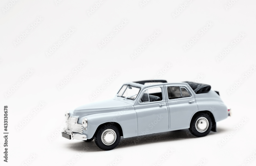 Miniature model of a retro car on a white background. A toy car model. Vintage car model.