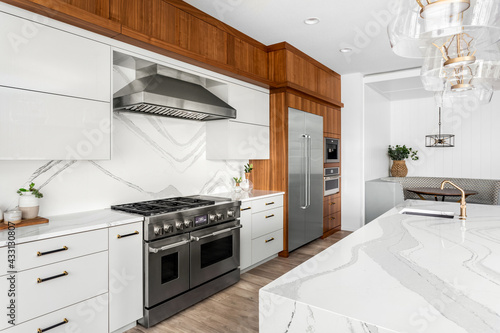Beautiful kitchen in new luxury home with large waterfall island, gorgeous backsplash and cabinets.  