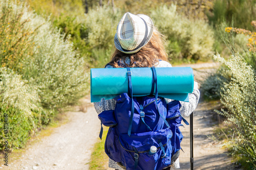 woman with travel backpack practicing hiking or pilgrimage