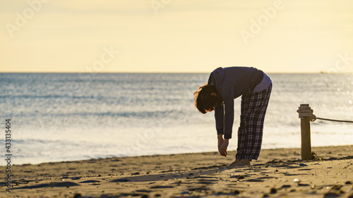 Woman exercising on beach at morning. photo