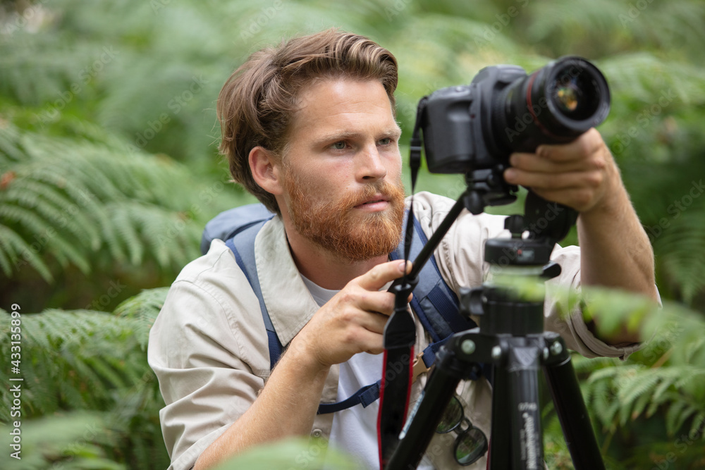 male photographer setting up camera on a tripod