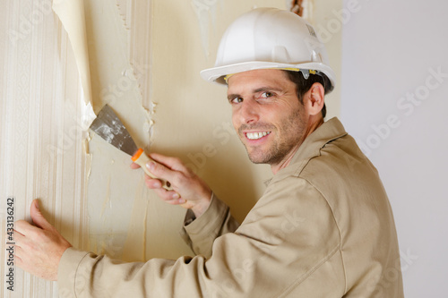 Canvas Print a man removing the wallpaper