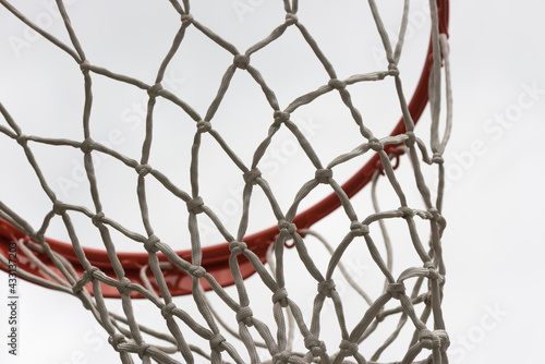 basketball hoop and net against a grey sky