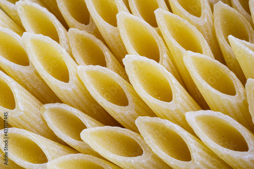 Close up view of uncooked penne pasta arranged in a pattern