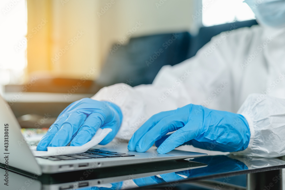 Close up hand using disinfectant for sanitizing laptop keyboard during COVID-19 pandemic. Close up hand using disinfectant for sanitizing laptop keyboard during COVID-19 pandemic.