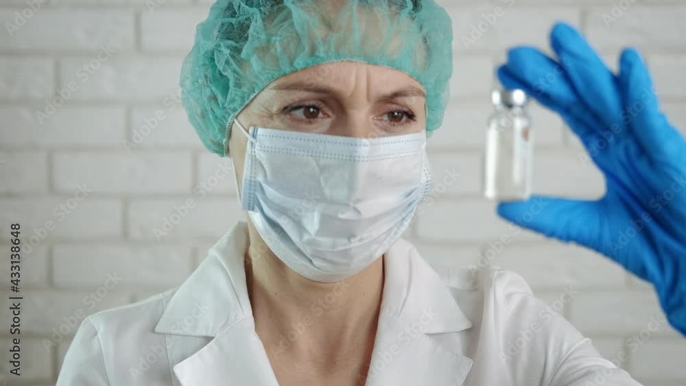 Scientist with vaccine ampoule. A scientist woman hold an ampoule with vaccine in the office. A concept of new medicine from coronavirus during epidemic. Scientist with vaccine ampoule. A scientist woman hold an ampoule with vaccine in the office. A concept of new medicine from coronavirus during epidemic.