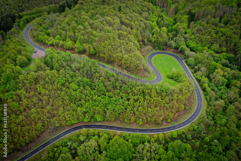 Serpentine - kurvenreiche Straße - Kurven im grünen Wald - Straßenschäden - Unfallschwerpunkt - Luftaufnahme Serpentine - kurvenreiche Straße - Kurven im grünen Wald - Straßenschäden - Unfallschwerpunkt - Luftaufnahme