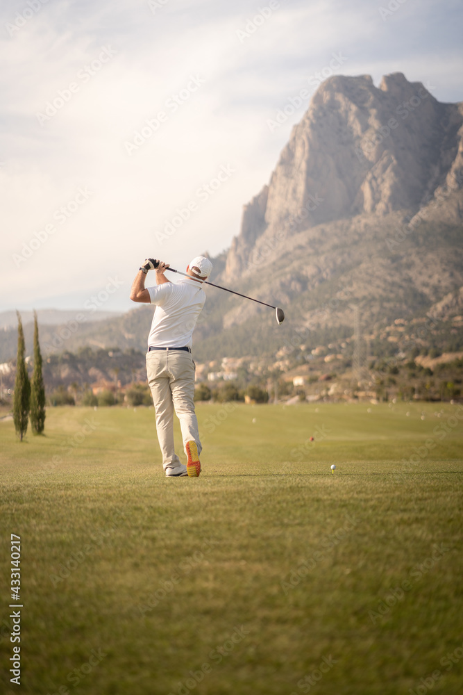 Golf player making a perfect swing on the golf course in the sunset. Golf player making a perfect swing on the golf course in the sunset.