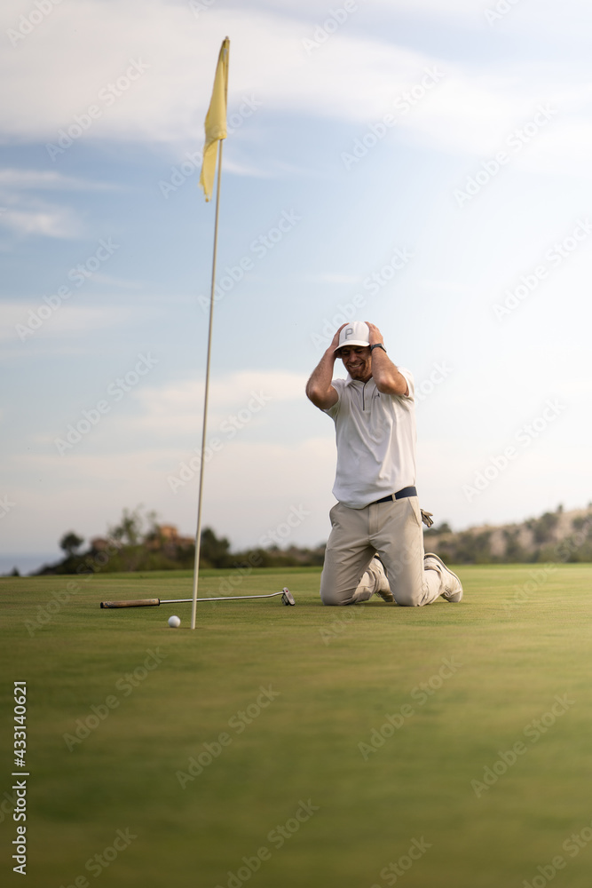 Obraz premium Angry golfer lamenting for missing his shot on the green a few inches from the hole.