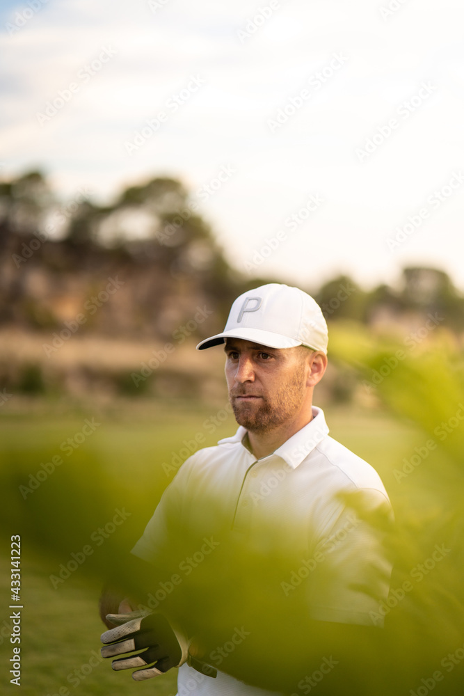 Concentrated golf player fitting his glove before swinging. Concentrated golf player fitting his glove before swinging.