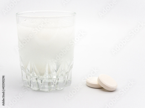 Photography pills and glass of water with disolving pills on white