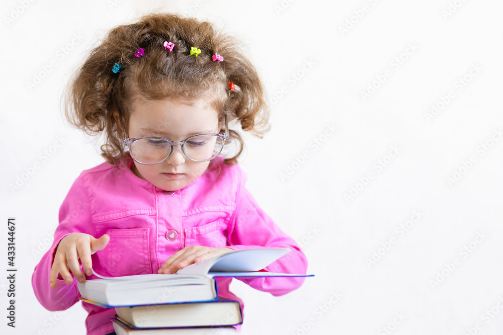 serious, brooding, cute smart little girl in funny big glasses reading a stack of paper books. Training, education, knowledge. back to school. child holding textbook, doing homework. copy space, text serious, brooding, cute smart little girl in funny big glasses reading a stack of paper books. Training, education, knowledge. back to school. child holding textbook, doing homework. copy space, text