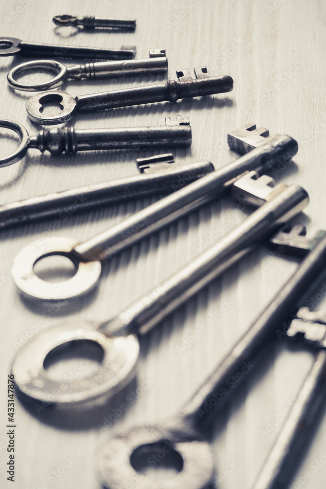 Different old fashioned keys on a white table Different old fashioned keys on a white table