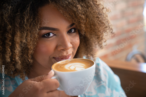 Fotografija woman drinking coffee with playfull gaze