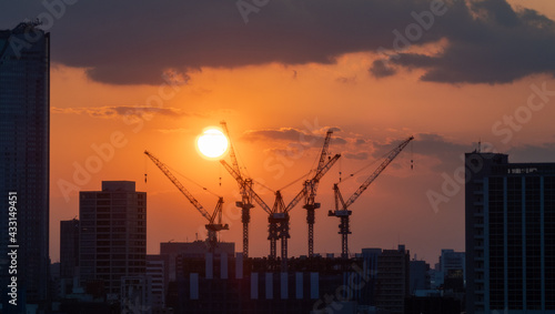 夕日と大型建築クレーン